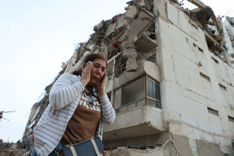 A woman walks past a building damaged during an earthquake in La Guaira, Venezuela, Thursday, June 25, 2026.